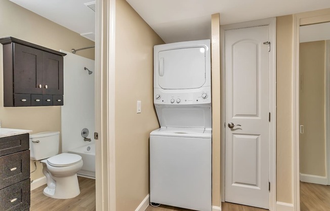 A washer/dryer unit is in a narrow hallway.