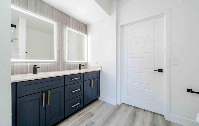 a bathroom with dark blue cabinets and a white door