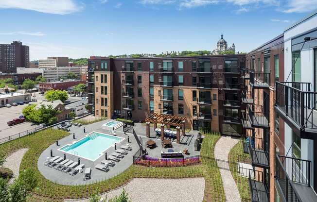 Stunning panoramic view from the balcony at Oxbo Urban Rentals. Large pool deck, outdoor lounge area, and St Paul skyline can be seen from the balcony.