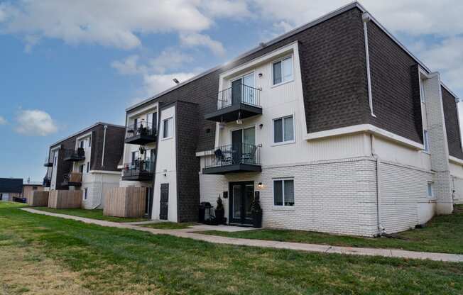 a row of apartments with balconies and a yard