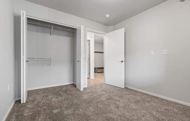 A room with a carpeted floor and a white door.