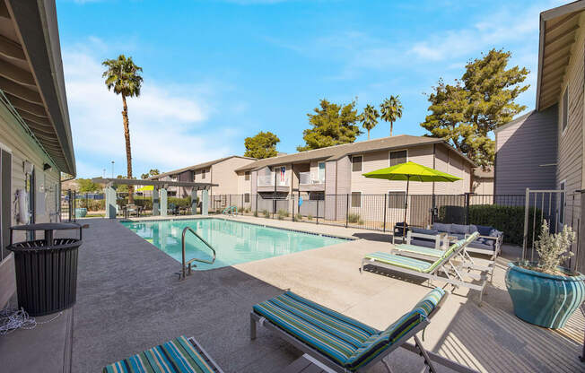 Swimming pool with lounge chairs and umbrellas at 2900 Lux Apartment Homes, Nevada