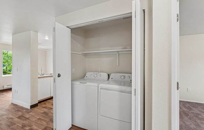 A white washer and dryer are in a small laundry room.