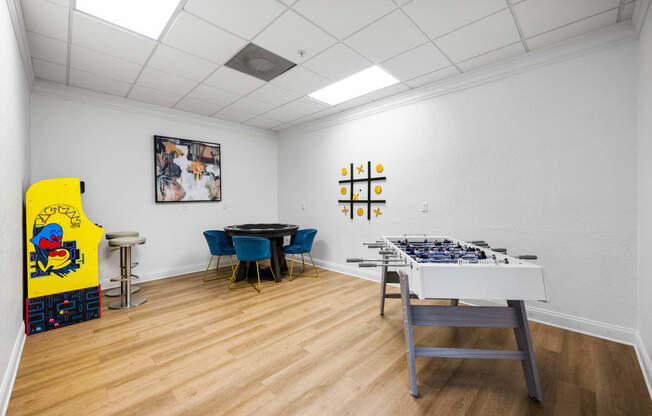 a room with a table with a giant chessboard and a game table and chairs