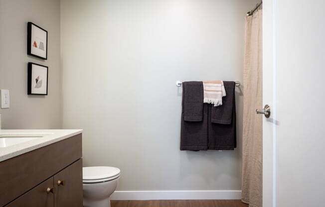 a bathroom with a toilet sink and towel rack and a shower at Slabtown Square Apartments, Portland , OR