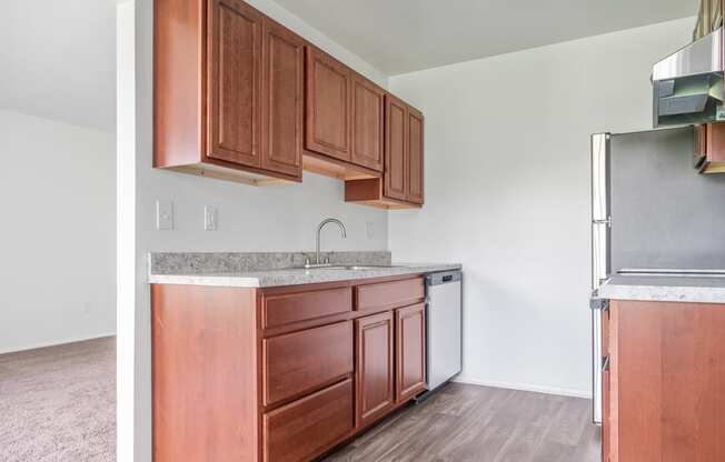 a kitchen with wooden cabinets and a stainless steel refrigerator