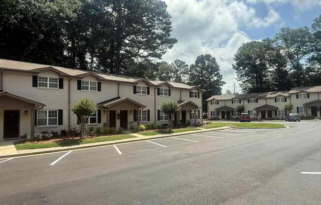 A row of houses with trees in the background.