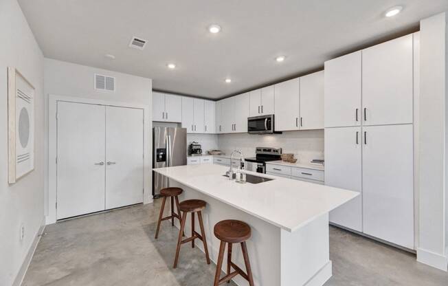 a large kitchen with white cabinets and a white counter top