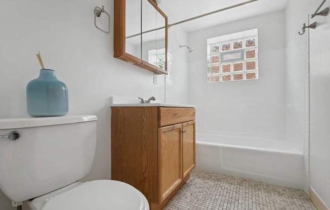 A white toilet sits next to a sink in a small bathroom.