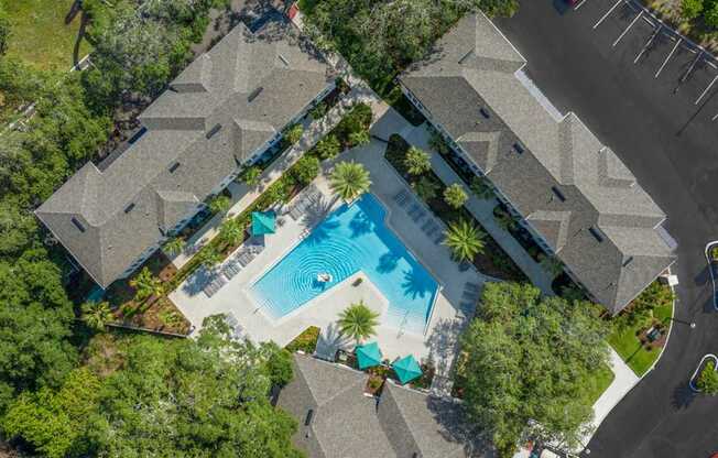 An aerial view of a residential area with houses and a swimming pool.