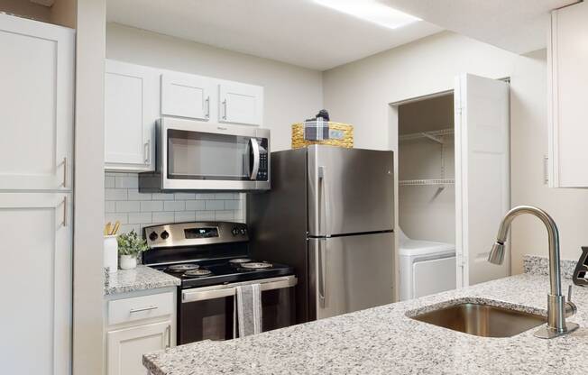 a kitchen with white cabinets and stainless steel appliances