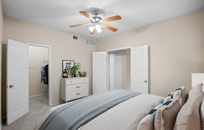 a bedroom with a large bed and a ceiling fan