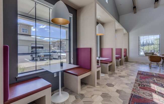 a dining area with tables and chairs and a large window with a view of a parking lot