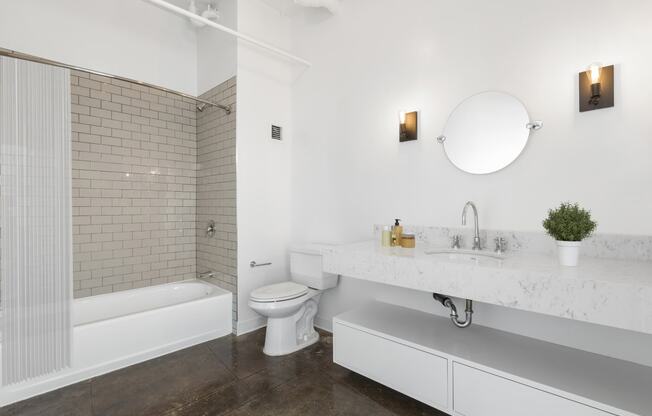 a white bathroom with a toilet and a tub and a sink