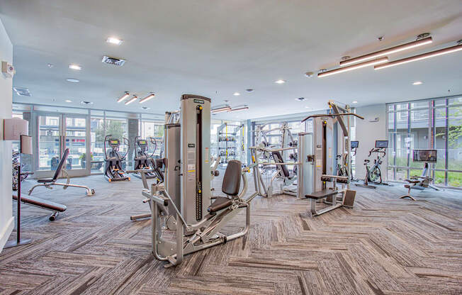 A gym with a variety of equipment including treadmills, weights, and exercise machines.
