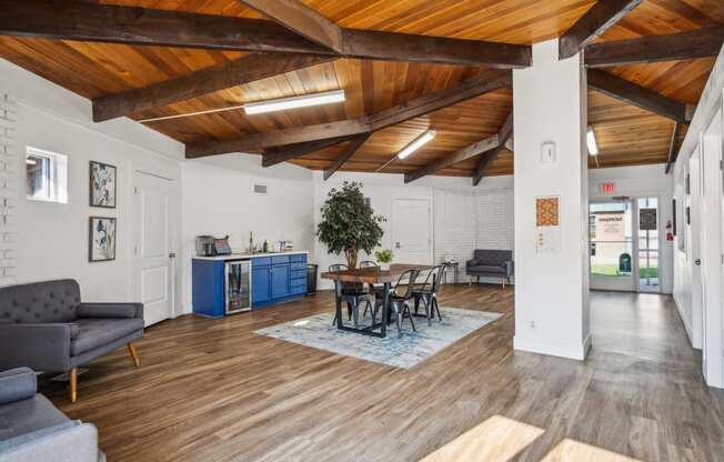 a living room with a wooden ceiling and a table and chairs