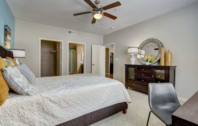 a bedroom with a large bed and a ceiling fan