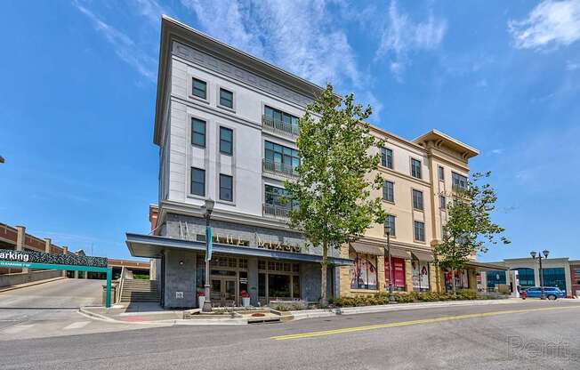 A street view of a building with a parking area in front.
