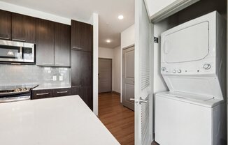 a kitchen with a washer and dryer and a door to a laundry room at Glenwood at Grant Park Apartments, Atlanta, GA