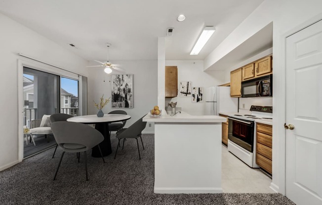 an open kitchen and dining area with a table and chairs and a large window