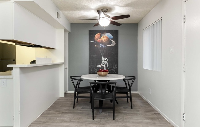 a dining room with a table and chairs and a ceiling fan