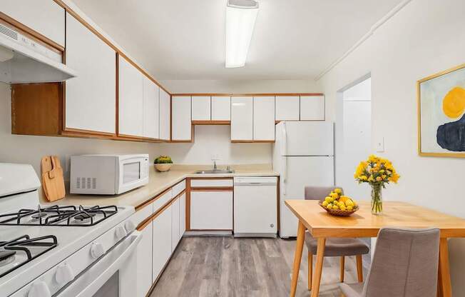 A kitchen with a white gas stove and a white refrigerator.