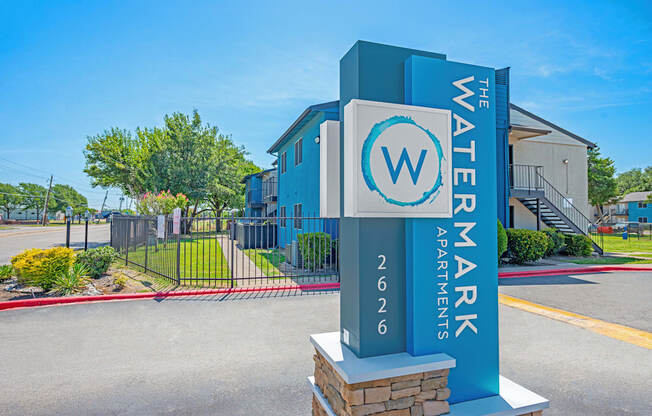 a blue and white sign is sitting in front of a building