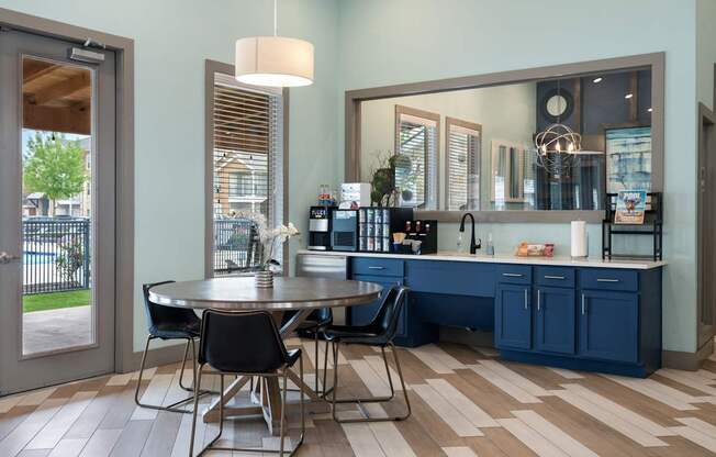 A kitchen with a table and chairs in front of a window.