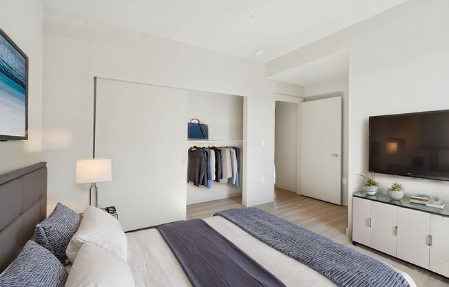 A bedroom with a large bed and a television in the corner.