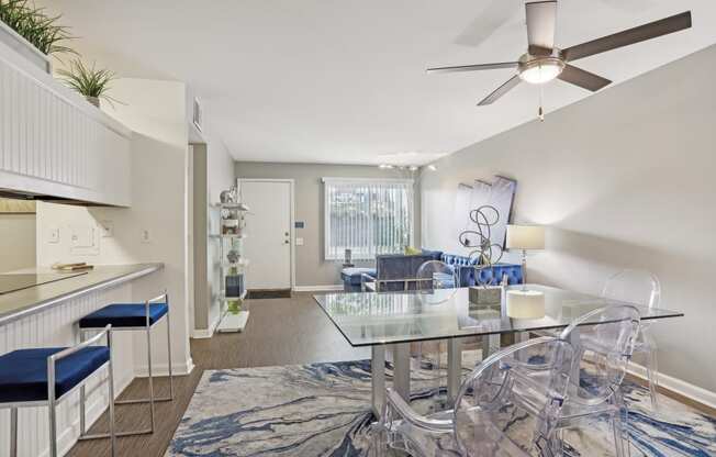 a dining room with a glass table and chairs and a living room