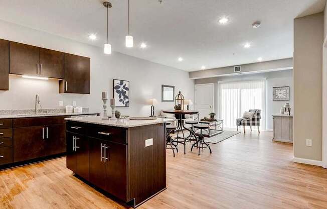 an open kitchen and living room with a dining room table. Circle Pines, MN Lexington Lofts