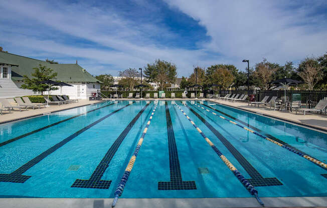 A large outdoor swimming pool with blue water and lane markers.