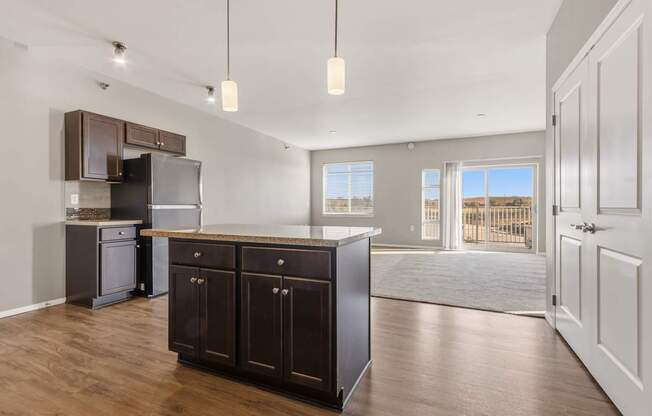 A kitchen with dark brown cabinets and a black refrigerator.