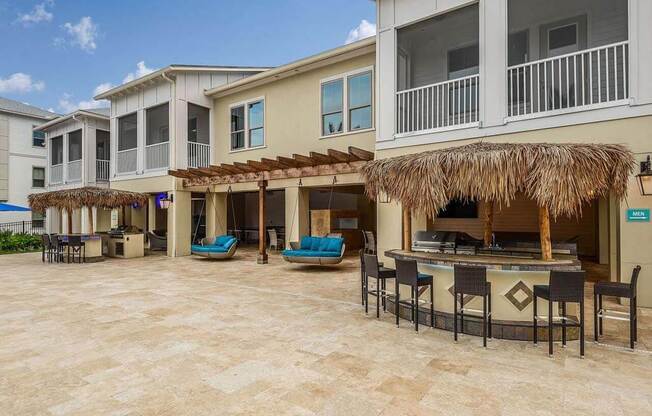 a patio with a bar and chairs in front of a building  at Palm Bay Club, Jacksonville, FL