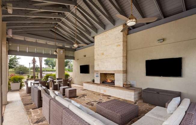 a patio with couches and a fireplace