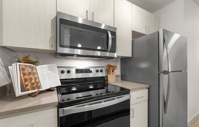 a kitchen with stainless steel appliances and white cabinets