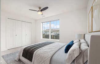 a white bedroom with a large bed and a ceiling fan at Stoney Pointe Apartment Homes, Wichita, KS