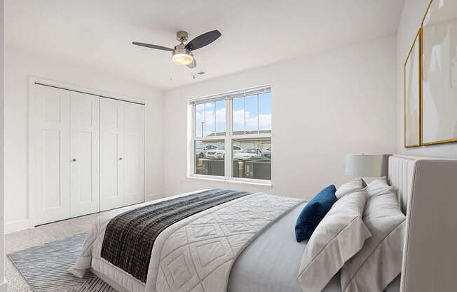 a white bedroom with a large bed and a ceiling fan at Stoney Pointe Apartment Homes, Wichita, KS