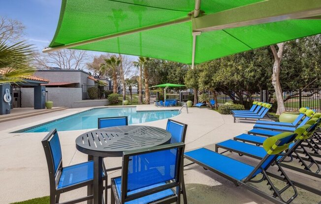 a patio with a table and chairs next to a swimming pool