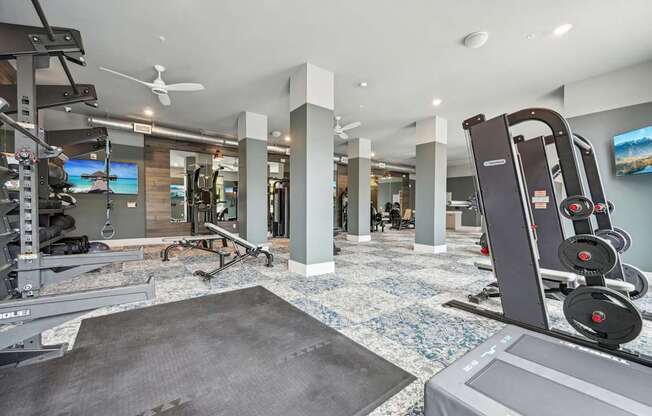 a gym with weights and other exercise equipment in a house at The Quarry Luxury Apartment Homes, Colorado, 80526
