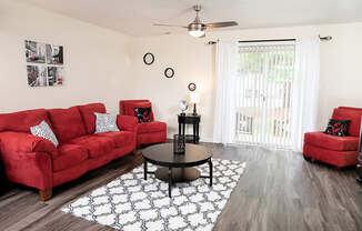 A living room with red couches and a black coffee table.