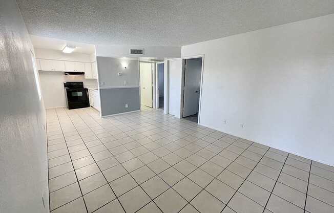 A spacious room with a tiled floor and white walls.