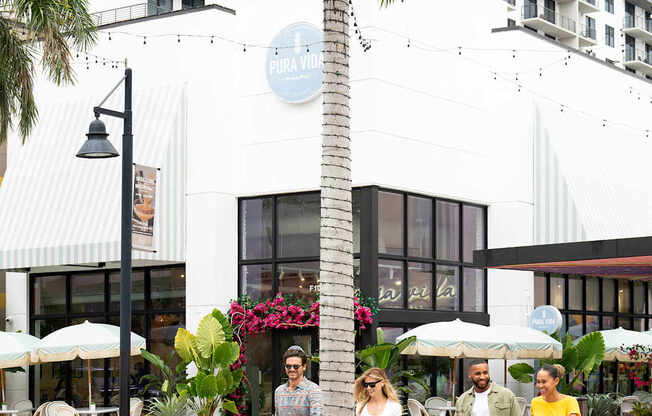Four people are walking across a crosswalk. at Palma, Doral, Florida