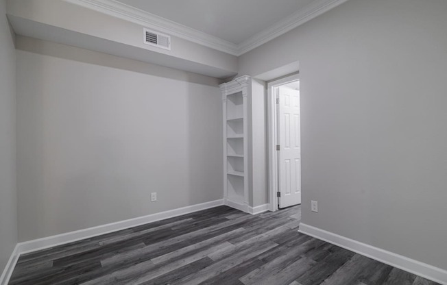 room with hardwood-style flooring and built-in shelving