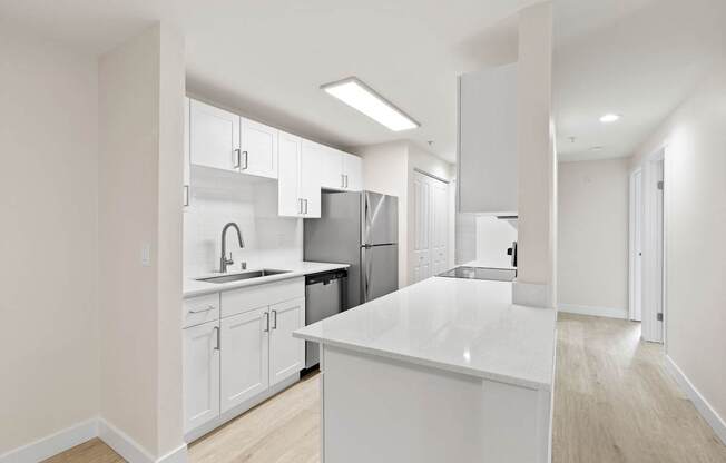 A modern kitchen with white cabinets and appliances.