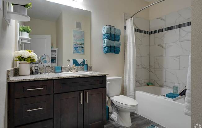 A bathroom with a white tub, toilet, and sink.