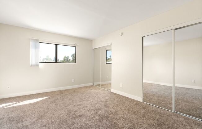 A room with a carpeted floor and a sliding glass door.