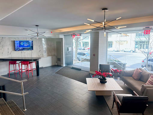 A modern living room with a bar area and a view of the street outside.