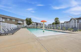 A swimming pool with a green pole and a red umbrella in the middle of it.