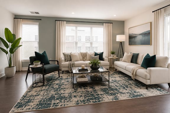 A living room with a white sofa, a black chair, and a coffee table.